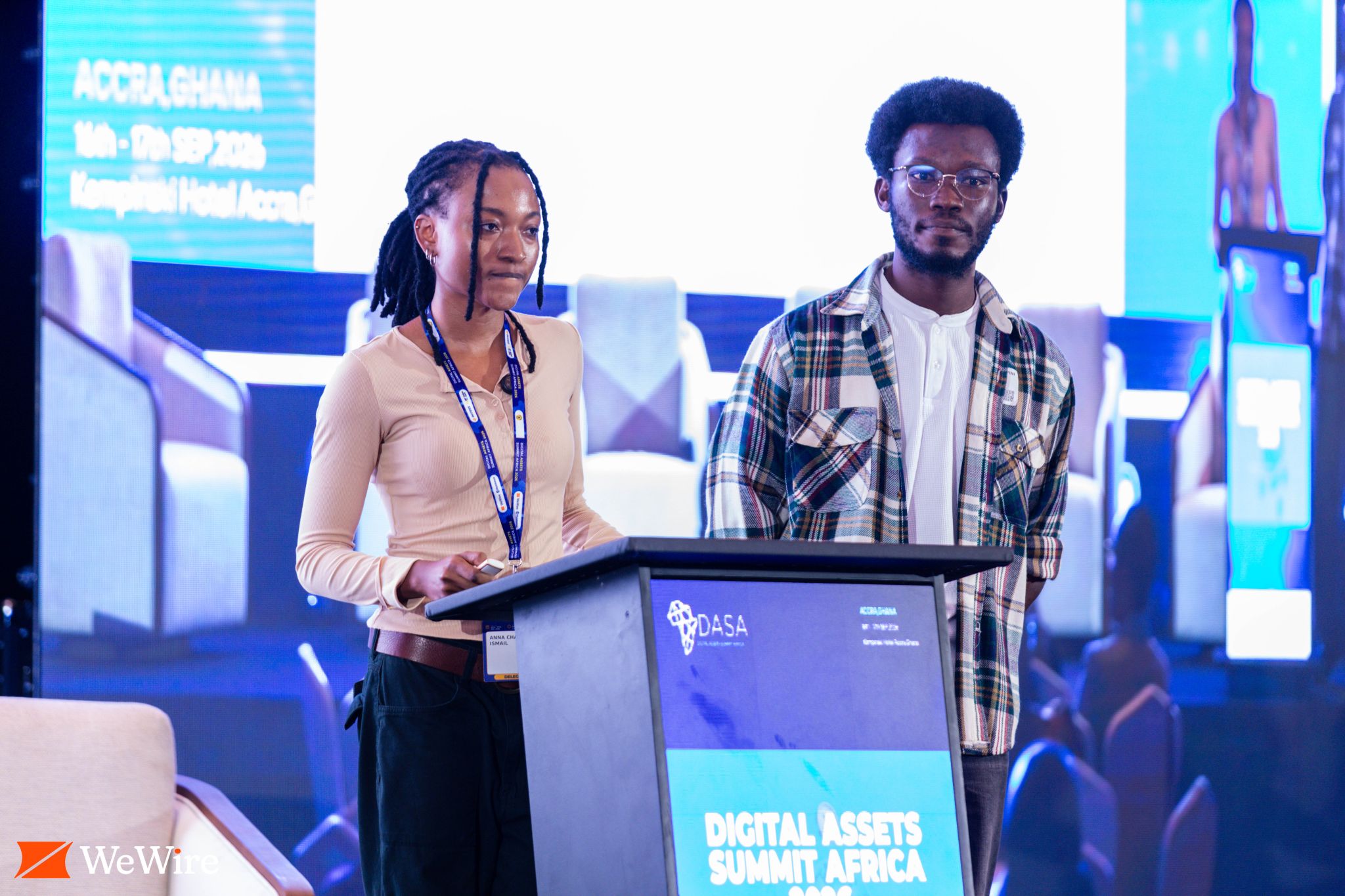 Two presenters stand at a podium on the Digital Assets Summit Africa stage.