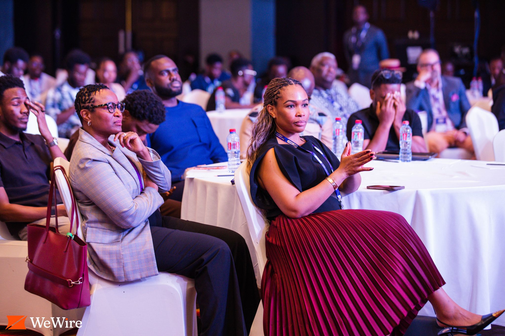 Event attendees sit at tables facing the stage.