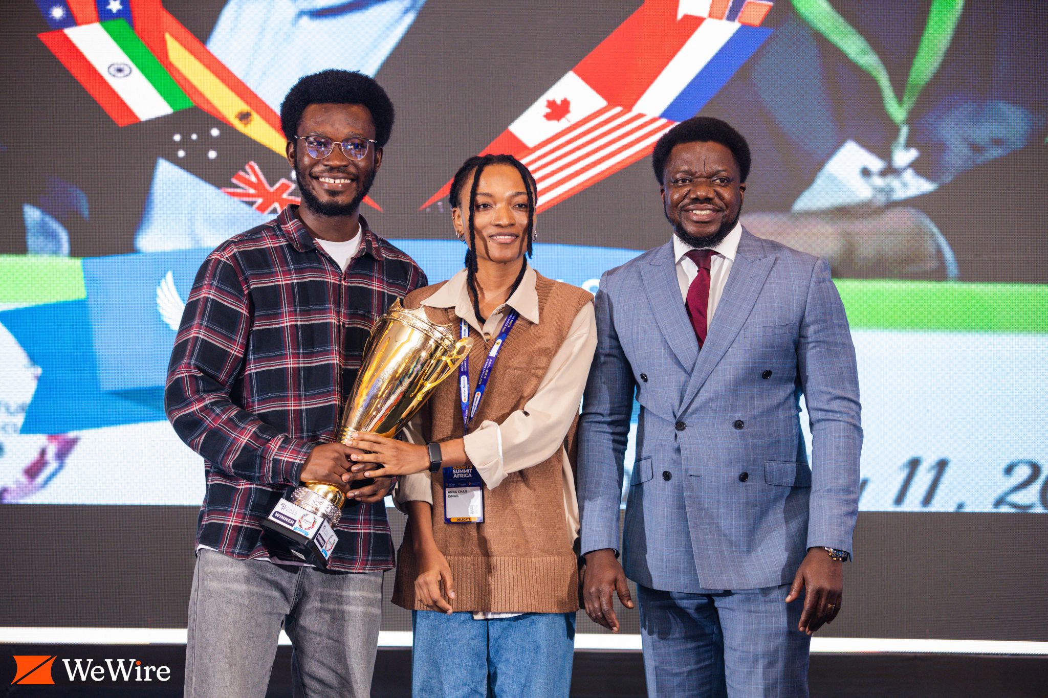 Three people pose together with the regional trophy.
