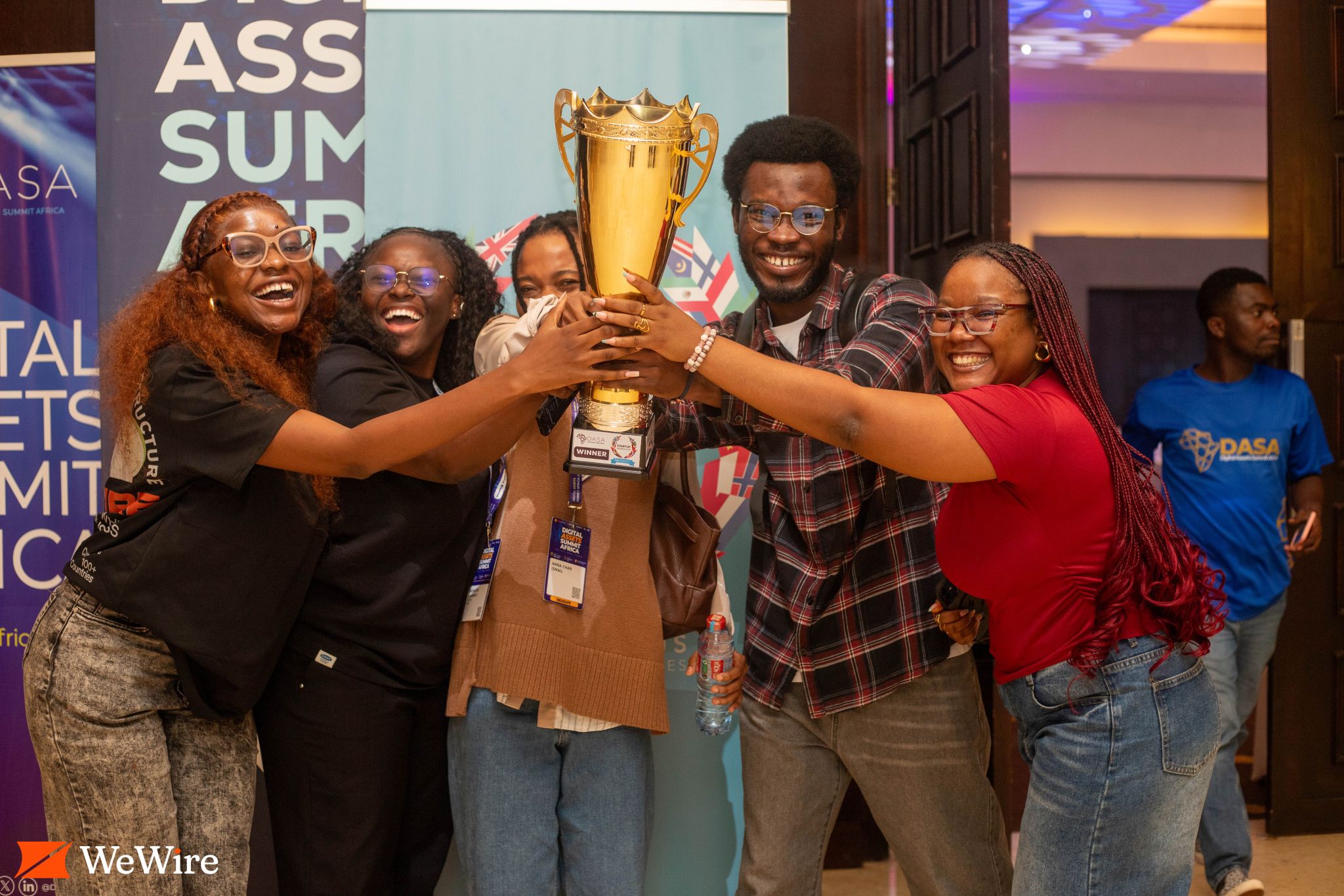 A group celebrates together while holding up the trophy.
